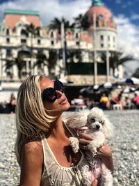 Woman holding dog at beach