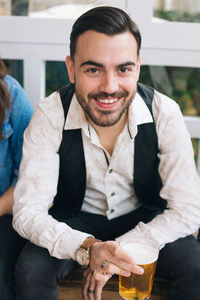 Portrait of smiling young man sitting outdoors