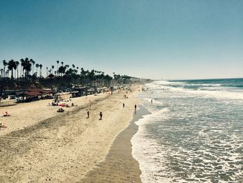 Panoramic view of people on beach against clear sky