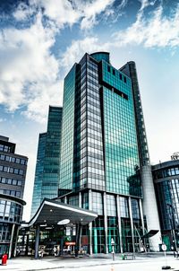 Low angle view of skyscrapers against cloudy sky