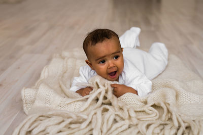 Portrait of cute boy lying on floor