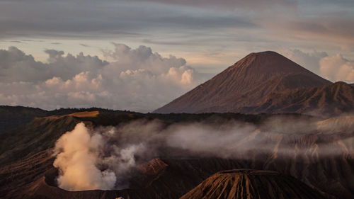 Smoke emitting from volcanic mountain against sky