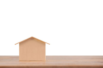 Close-up of model home on table against white background