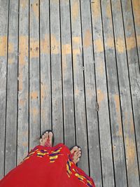 Low section of person standing on wooden boardwalk