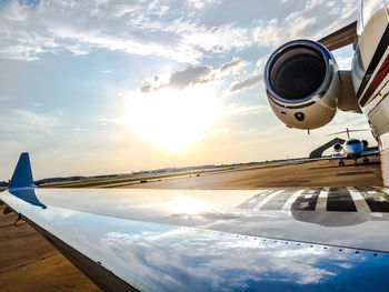 Airplane flying at airport runway against sky