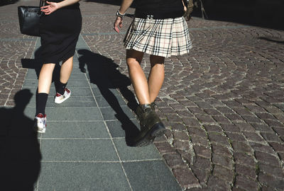 Low section of women walking on footpath