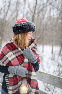 Woman with umbrella on snow covered tree