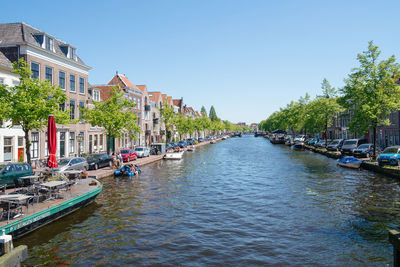 Canal amidst buildings against sky in city