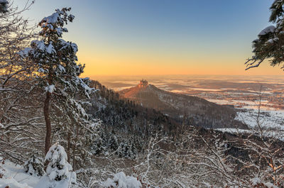 Scenic view of snow covered landscape against sky during sunset