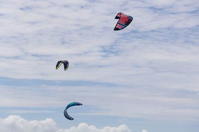 Low angle view of person paragliding against sky