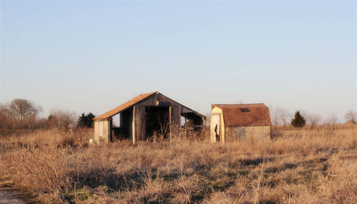 Abandoned house on field against clear sky