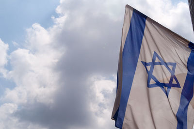 Low angle view of flag against blue sky