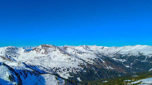 Scenic view of snowcapped mountains against clear blue sky