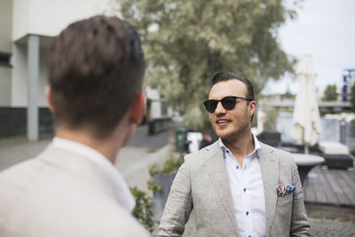 Portrait of young man with sunglasses standing outdoors