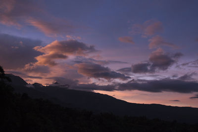 Scenic view of silhouette mountains against dramatic sky