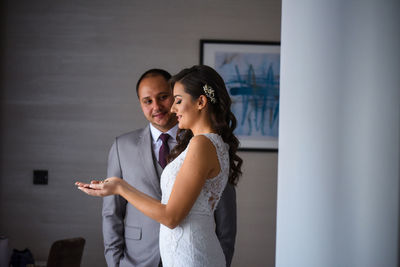 Young couple standing against wall