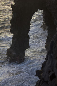 Rock formation in sea against sky