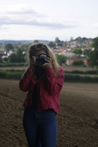 Midsection of woman standing on land against sky