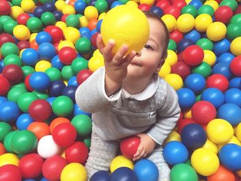 High angle view of baby boy playing with colorful balls