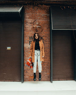 Full length of woman standing against door