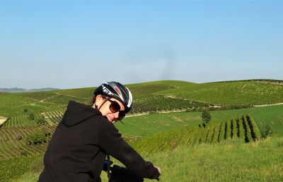 Woman riding electric bicycle on grassy hill at piedmont