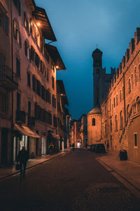 Street amidst buildings in city at night