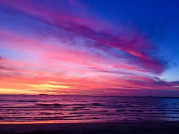 Scenic view of sea against dramatic sky during sunset