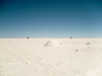 Scenic view of desert against clear blue sky