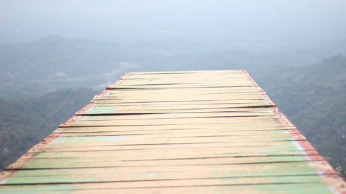 Close-up of pier over lake against mountain