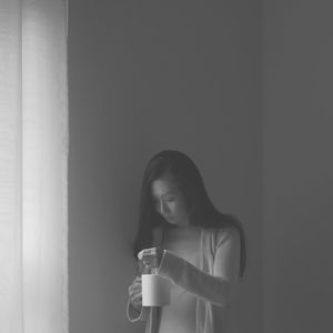 Portrait of young woman drinking coffee cup at home