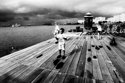 Rear view of man standing on jetty