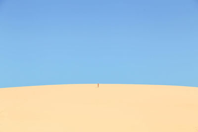 Scenic view of desert against clear blue sky