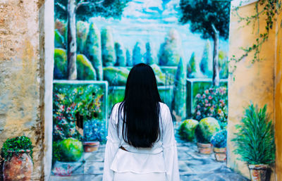 Rear view of woman standing against plants