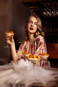 Portrait of woman holding ice cream in restaurant