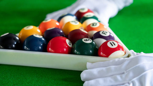 Close-up of hand holding balls on pool table