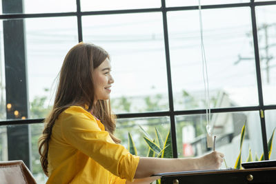 Smiling businesswoman working on table at office