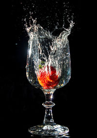 Close-up of water splashing in glass against black background