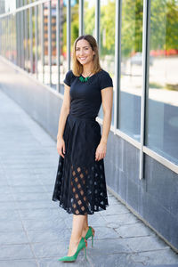 Portrait of woman standing against wall