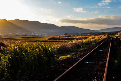 Panoramic shot of railroad track on field against sky