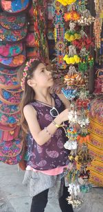 Cute girl looking at key rings at market