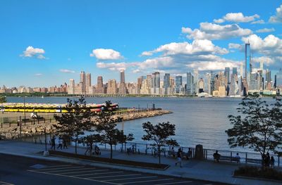 Scenic view of river by buildings against sky