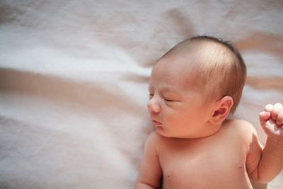 Close-up of cute baby sleeping on bed