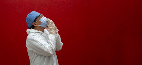 Midsection of woman standing against red wall