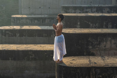 Full length of woman standing against wall