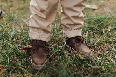 Low section of man standing on grassy field