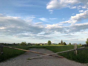 Road amidst field against sky