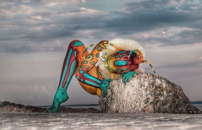 Close-up of statue by sea against sky