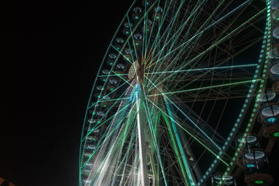 Low angle view of illuminated ferris wheel against sky at night