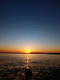 Scenic view of sea against clear sky during sunset