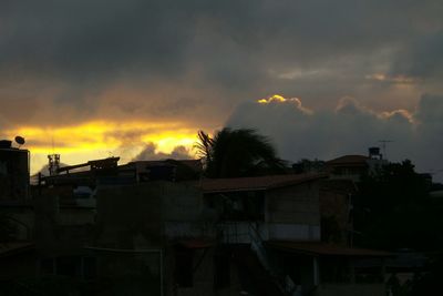 Silhouette of building against cloudy sky at sunset